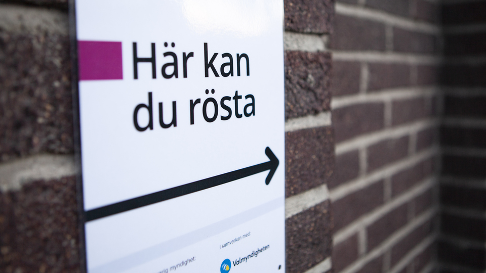 Tegelvägg med en skylt där det står "Här kan du rösta".