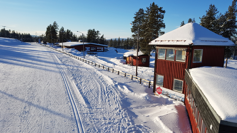 Skidspår och röda trähus på skidstadion i Sveg.